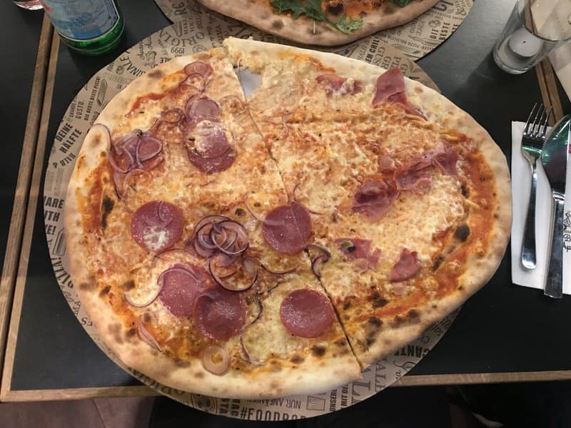 Pizza, halb mit Salami, halb mit Schinken belegt